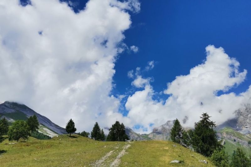 Mountains, trees, and clouds in Valais, Switzerland.