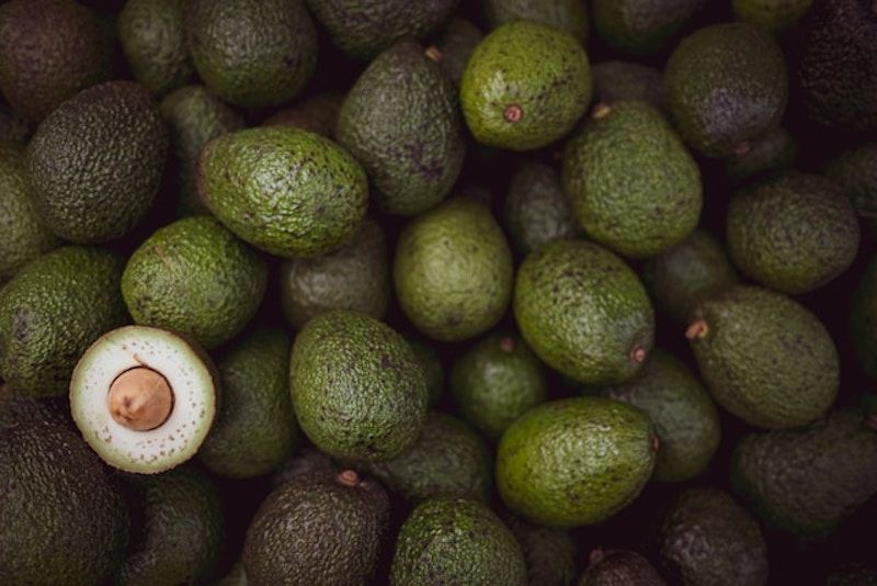several avacados with one sliced open