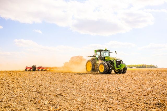 a green and yellow tractor out in the fields